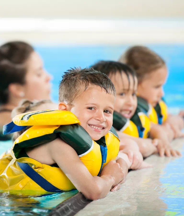 dzieci w basenie w żółtych kamizelkach
