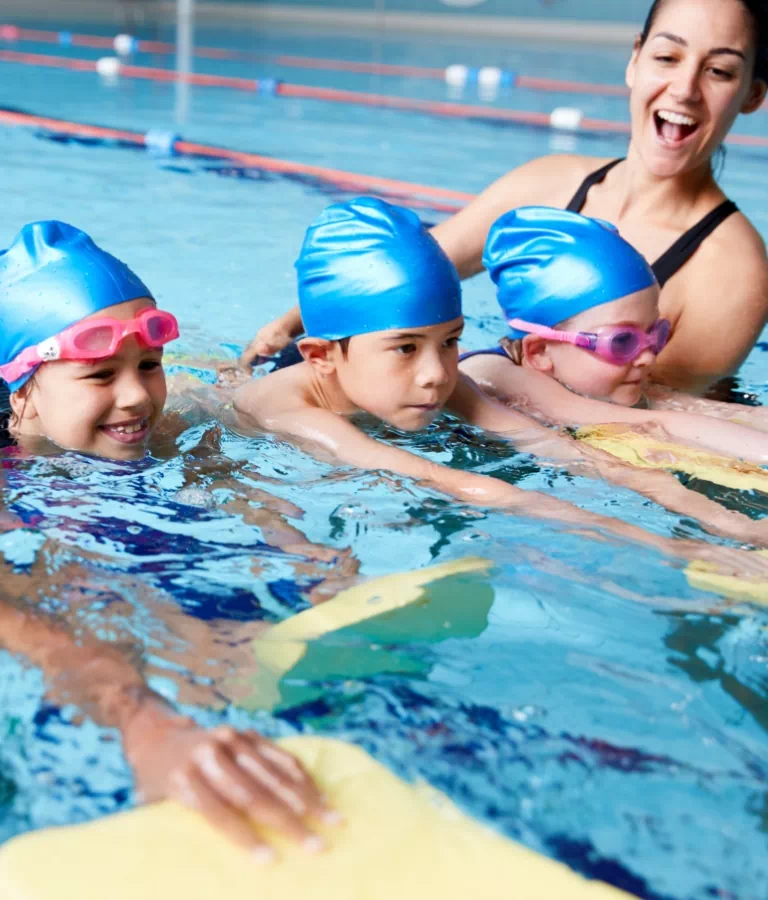 dzieci z instruktorem nauki pływania